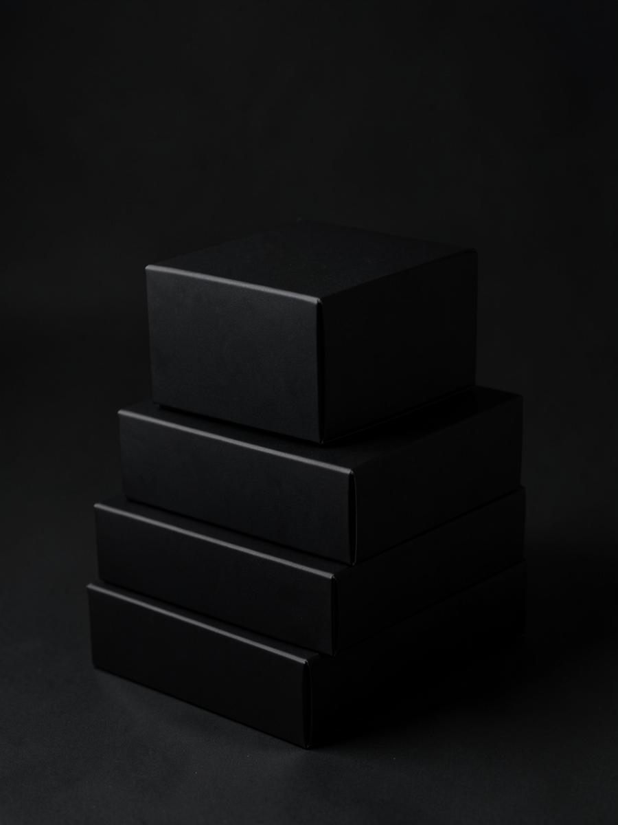 Stacked matte black craft packaging boxes